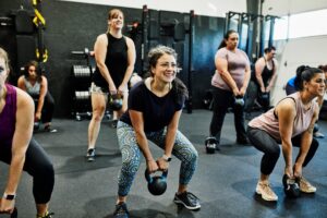 woman exercising in a fitness class using a kettlebell